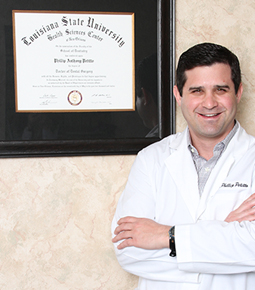 Dr. Petitto standing with hung diploma smiling